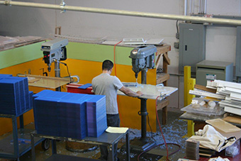 Worker operating a drill press