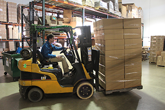 Forklift driver with a load of shiping boxes