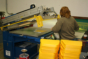 Worker operating a slikscreening machine