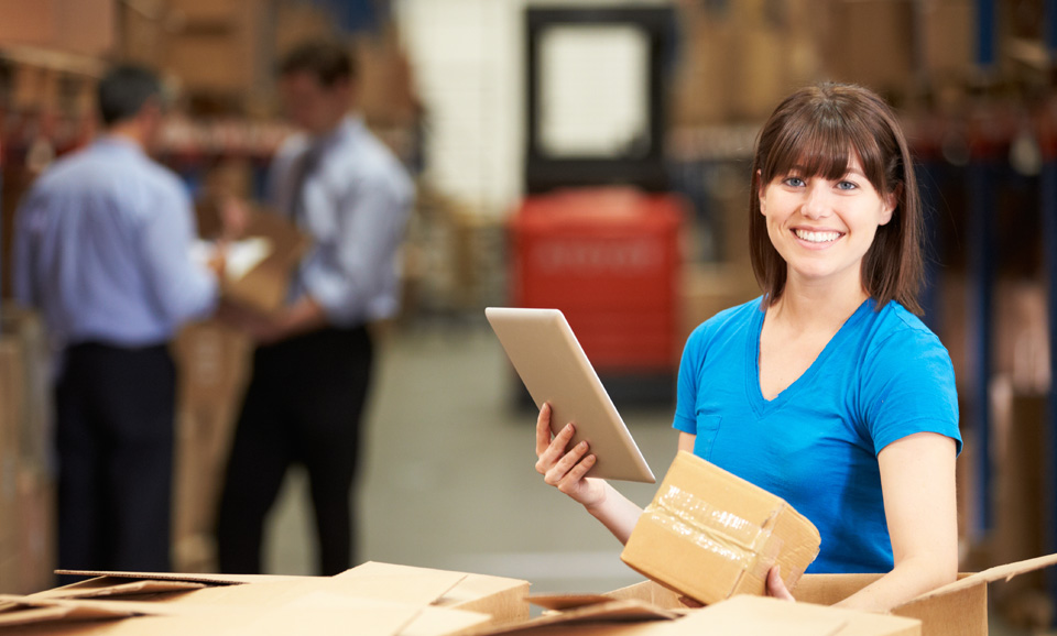 Worker with shipping boxes in warehouse